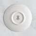 A white porcelain saucer with black text and a crown logo.