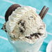 A scoop of Cookie Dough Bliss Cookies and Cream cookie dough on a ice cream sundae.
