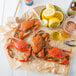 Steamed Chesapeake blue crabs on paper with lemons and beer.