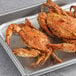 A metal tray of seasoned steamed female Chesapeake crabs.