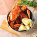A bowl of Chesapeake blue crabs with lemon wedges.