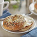 A bagel with cream cheese and Regal Salt-Free Everything Bagel Seasoning on a plate.