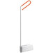 A white rectangular object with a long orange plastic handle.