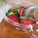 A Dart clear plastic bowl with strawberries inside.