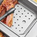A silver tray with bacon in a Vigor stainless steel steam table pan.