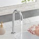 A person washing their hands with a Waterloo deck mount sensor faucet.