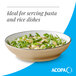 A tan matte stoneware pasta bowl filled with pasta and greens.
