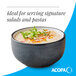 A matte midnight blue stoneware bowl filled with a creamy dish and garnished with herbs.