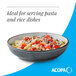 A matte midnight blue stoneware pasta bowl filled with pasta and vegetables.