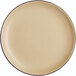 A close up of an Acopa Harvest Tan Matte Coupe stoneware plate with a black rim.