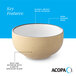 A tan matte stoneware bowl with a speckled exterior, glossy white interior, and a dark banded edge.