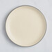 An Acopa Embers stoneware plate with a cream white matte finish and black rim.