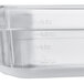A close up of a translucent polypropylene food pan with measuring cups.