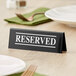 A Tablecraft double-sided "Reserved" sign on a table.