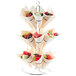 A Tablecraft chrome-plated steel cone holder with fruit in cones.