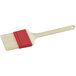 A natural bristle pastry and basting brush with a white handle.