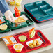 A red Choice heavy-duty melamine compartment tray with food and a fork in it.