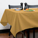 A table with a yellow Intedge tablecloth and a plate of food.