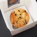 A chocolate chip muffin in a white Baker's Mark box with a reversible insert for one muffin.