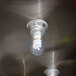 A FMP shatterproof glass globe covering a spiral light bulb on a metal surface.