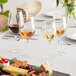 A table with Della Luce Maia white wine glasses and food on it.
