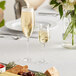 A table with two Della Luce Maia champagne flute glasses filled with champagne.