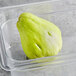 A plastic container of fresh green chayote squash.