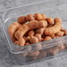 A plastic container full of brown tamarind.
