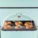 A Cal-Mil Classic dome cover with a tray of bagels and a clear handle.