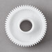 A white plastic Galaxy brush drive gear with a hole in the middle.