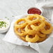 A plate of fried Golden Dipt Modern Maid Crispy Fry onion rings with dipping sauce.