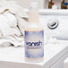A bottle of Noble Chemical Vanish laundry pre-spotter on top of a washing machine.