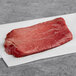 An 8 oz. raw TenderBison bison top sirloin steak on a white paper.