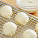 A ball of white dough on a metal rack.