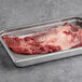 A metal tray with a TenderBison Bison Brisket Flat inside.