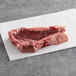 A piece of raw TenderBison New York Strip Steak on a white surface.