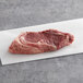 A TenderBison bone-in center-cut bison New York strip steak on a white surface.