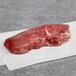 A raw TenderBison ranch steak on white paper.