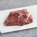A TenderBison raw top sirloin steak on a white plate.