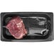 A TenderBison bison tenderloin steak in a black plastic container.