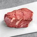 A piece of raw TenderBison bison tenderloin steak on a white surface.
