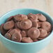 Milk chocolate wafers melted in a bowl.