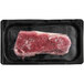 A TenderBison New York strip loin steak in a black tray.