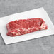 A piece of TenderBison raw bison New York strip loin steak on white paper.