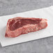 A TenderBison bone-in bison New York strip steak on a white paper.