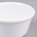 A close-up of a white Thunder Group smooth melamine ramekin on a gray surface.