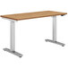 A HON natural wood height-adjustable desk with silver legs.