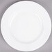 An Arcoroc white porcelain plate with a white rim on a gray surface.