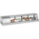 A Turbo Air stainless steel curved glass refrigerated sushi case filled with a variety of food.