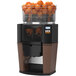 A Zummo Z14 commercial juicer with oranges inside.